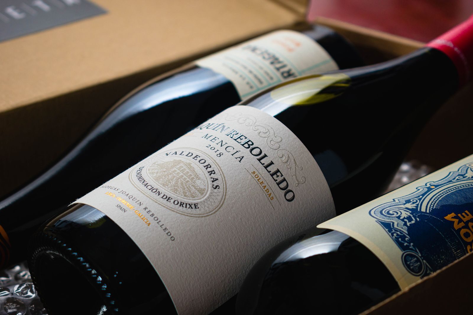 Detailed close-up of assorted wine bottles with elegant labels in a packaging box.